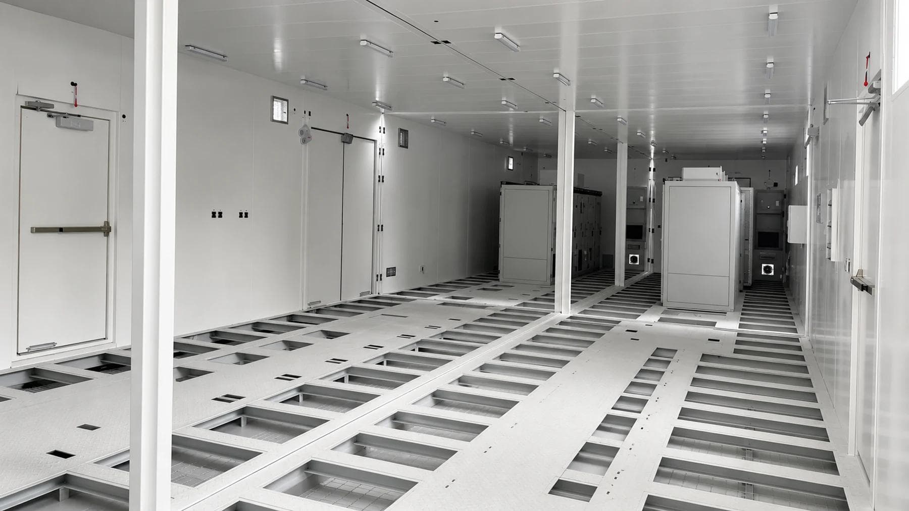 Interior of an assembled double-bay synchronous condenser E-House showing equipment bases, cable trench framing and maintenance aisles