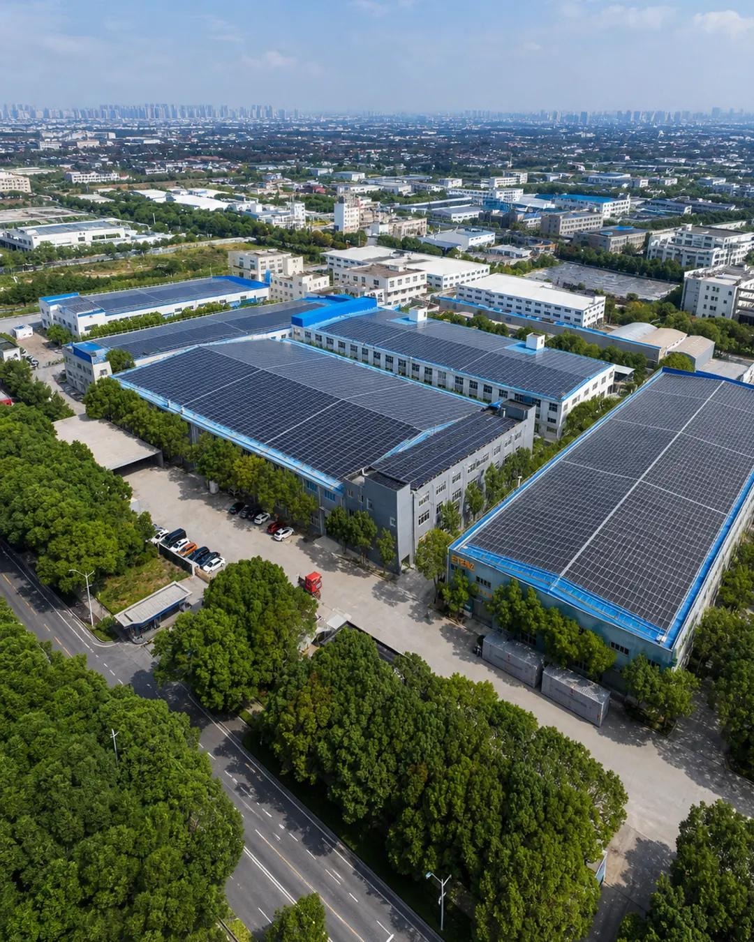 Oblique aerial view of the ETENZ manufacturing campus showing multiple factory halls and rooftop solar panels